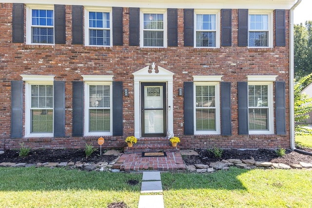 colonial inspired home featuring a front lawn