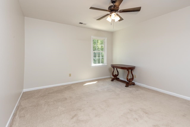 empty room featuring ceiling fan and light carpet