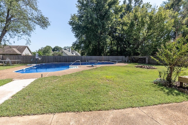 view of swimming pool with a lawn and a diving board