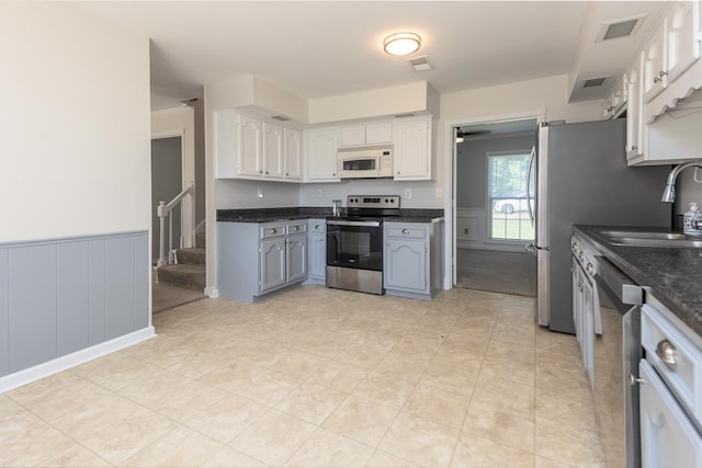 kitchen with stainless steel appliances, white cabinetry, and sink