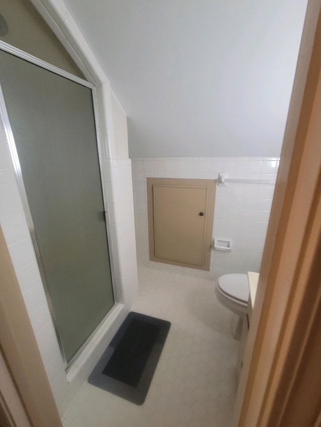 bathroom featuring tile walls, toilet, and an enclosed shower