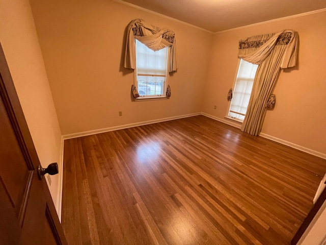 spare room featuring wood-type flooring, a healthy amount of sunlight, and crown molding