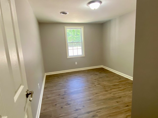 spare room with dark hardwood / wood-style flooring