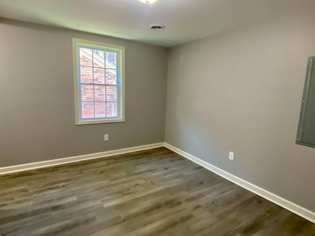 spare room featuring electric panel and hardwood / wood-style flooring