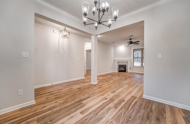 unfurnished living room featuring crown molding, wood-type flooring, a tile fireplace, and ceiling fan