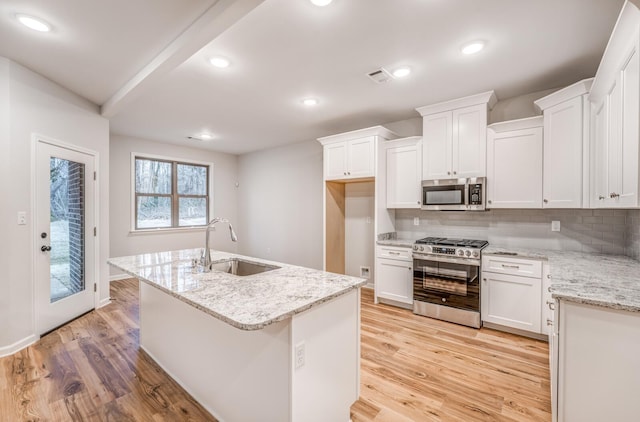 kitchen featuring white cabinetry, sink, a center island with sink, and appliances with stainless steel finishes