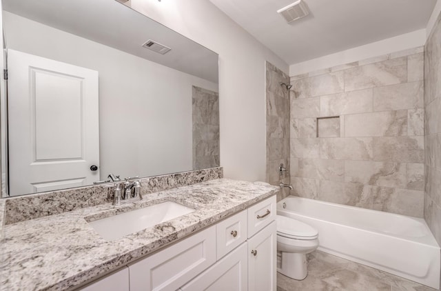 full bathroom with tiled shower / bath, vanity, and toilet