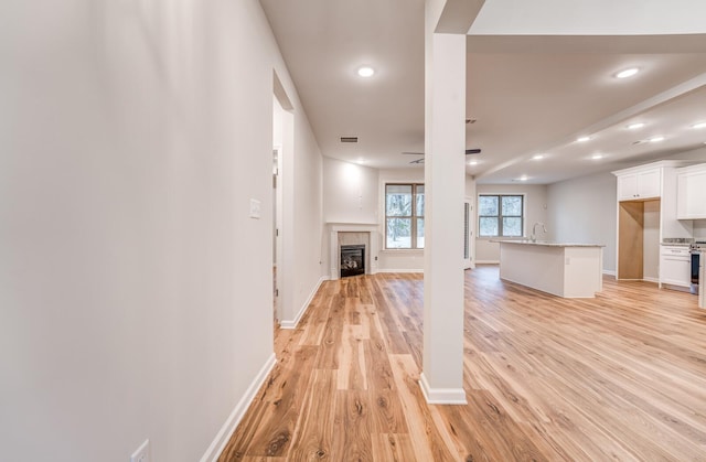 unfurnished living room with light hardwood / wood-style flooring and a tile fireplace