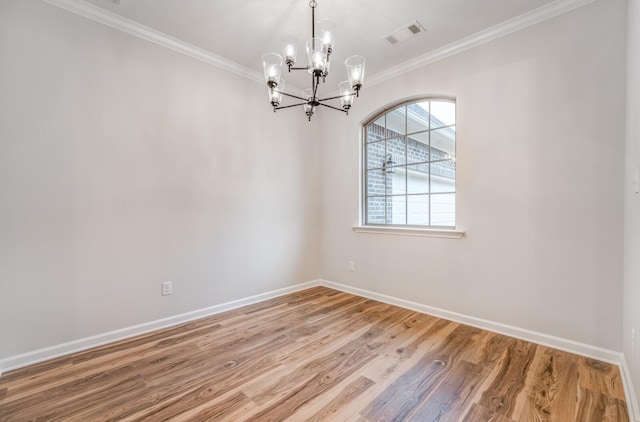 spare room featuring an inviting chandelier, hardwood / wood-style floors, and ornamental molding