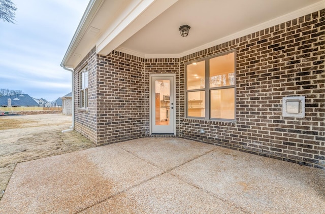 view of exterior entry with a patio area