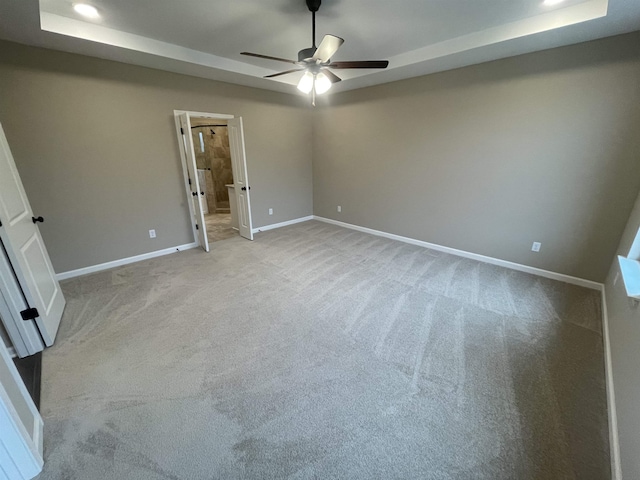 unfurnished bedroom featuring light carpet, baseboards, a raised ceiling, a ceiling fan, and recessed lighting