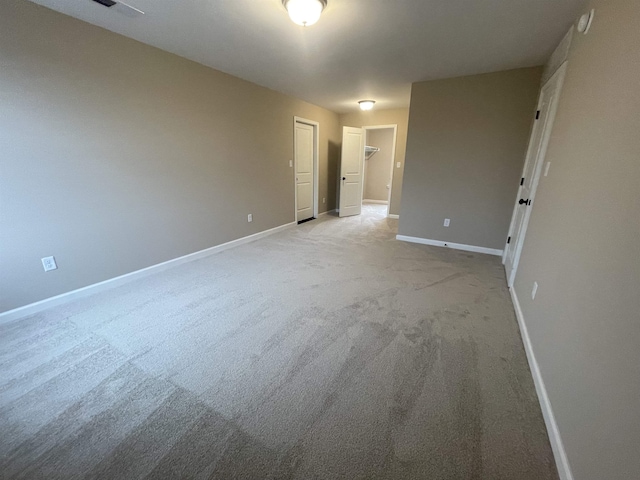 empty room featuring light carpet and baseboards