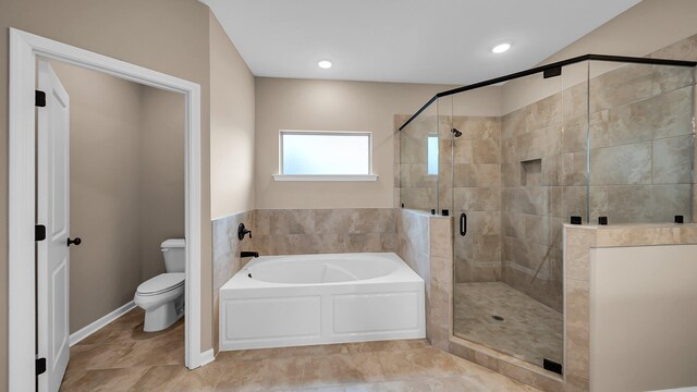 bathroom featuring a stall shower, a garden tub, and toilet