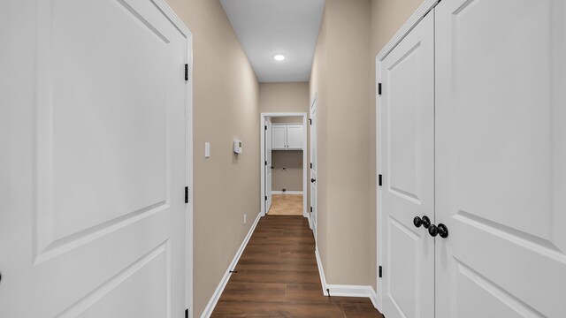 hallway featuring dark wood-style floors and baseboards