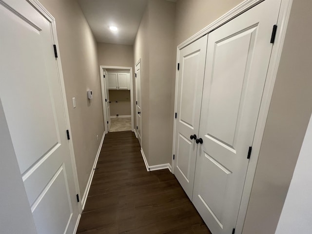 hall with baseboards and dark wood-type flooring