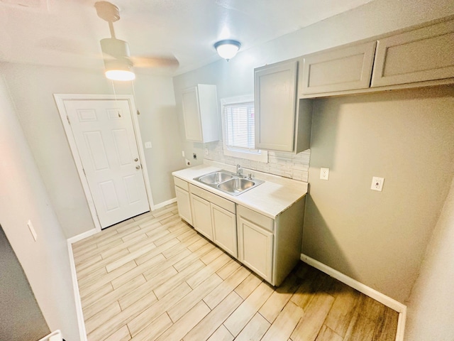 kitchen with decorative backsplash, sink, ceiling fan, and light hardwood / wood-style flooring