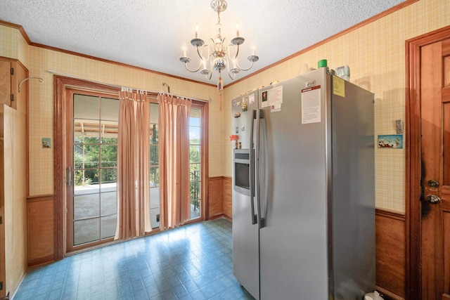 kitchen with a textured ceiling, crown molding, stainless steel fridge with ice dispenser, and a notable chandelier