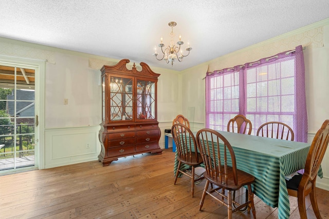 dining space with an inviting chandelier, hardwood / wood-style flooring, crown molding, and a wealth of natural light