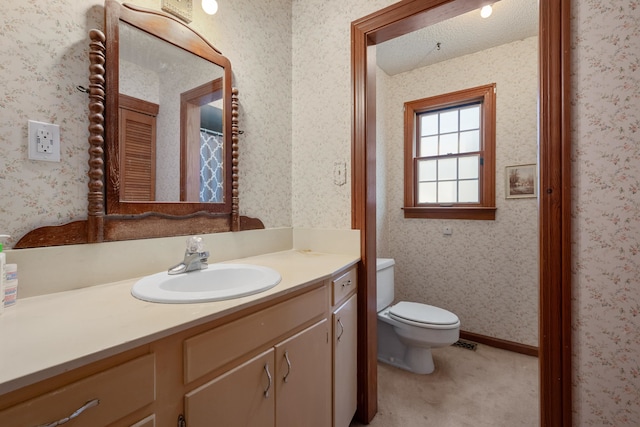 bathroom featuring a textured ceiling, vanity, and toilet