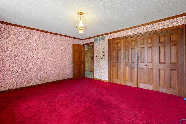 unfurnished bedroom featuring a textured ceiling, carpet, and ornamental molding