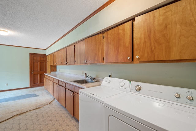 laundry room with washer and clothes dryer, cabinets, sink, and a textured ceiling