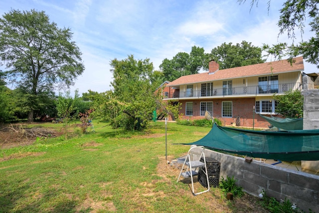 view of yard with a balcony