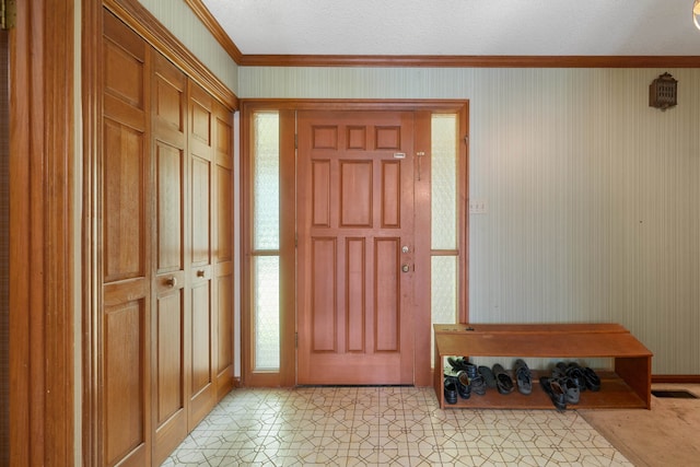 foyer entrance with a textured ceiling, plenty of natural light, and crown molding