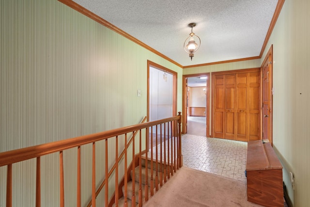 hallway featuring a textured ceiling, ornamental molding, and light colored carpet