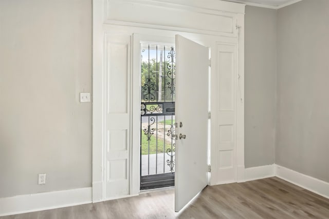 entryway with hardwood / wood-style flooring and ornamental molding