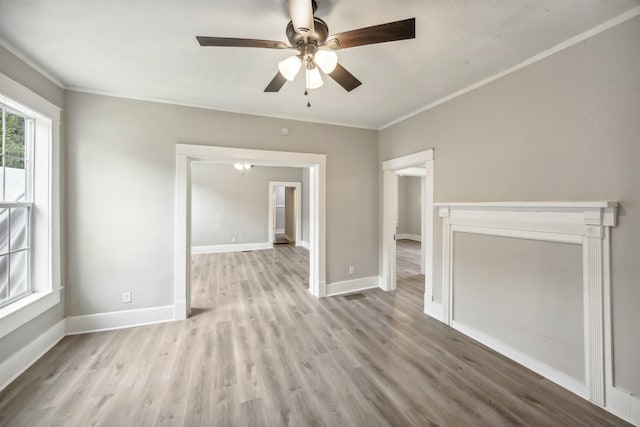 empty room with ceiling fan, crown molding, and light hardwood / wood-style floors