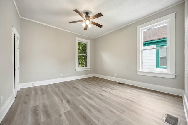 spare room featuring light hardwood / wood-style flooring, ceiling fan, a healthy amount of sunlight, and a textured ceiling