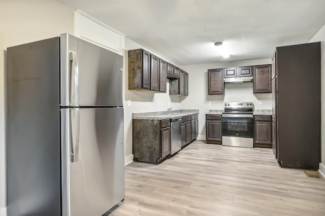 kitchen with appliances with stainless steel finishes, light hardwood / wood-style floors, dark brown cabinets, and sink