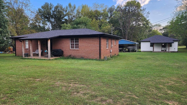 rear view of property featuring a lawn and a patio