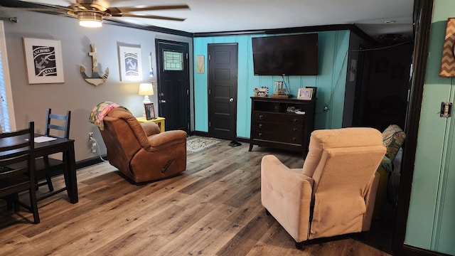 living room featuring ornamental molding, ceiling fan, and hardwood / wood-style flooring