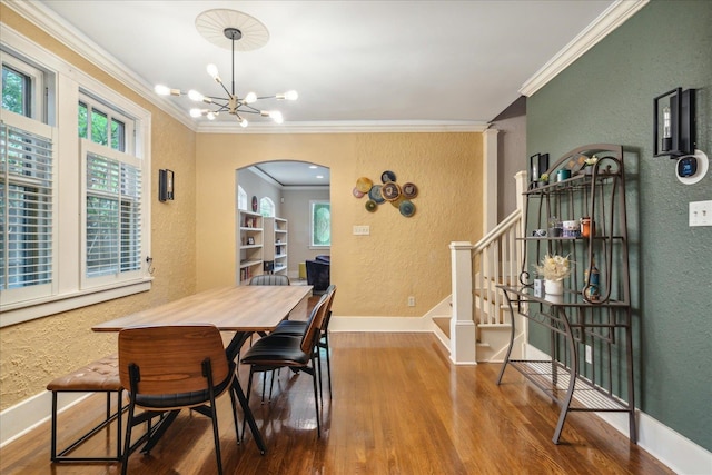 dining room with wood-type flooring, a notable chandelier, and ornamental molding