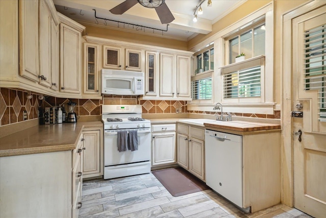 kitchen featuring white appliances, crown molding, ceiling fan, cream cabinets, and sink