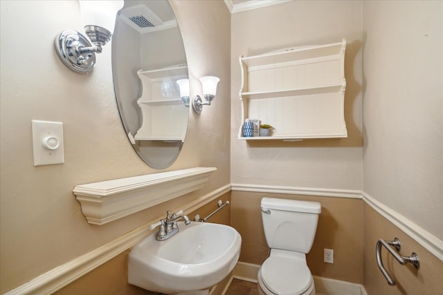 bathroom with ornamental molding, sink, and toilet