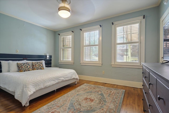 bedroom featuring ornamental molding, dark wood-type flooring, and ceiling fan