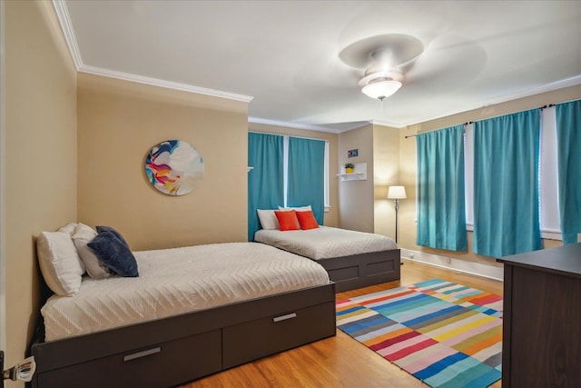 bedroom featuring crown molding, light hardwood / wood-style floors, and ceiling fan