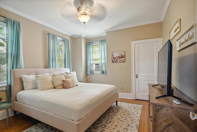 bedroom with ceiling fan, hardwood / wood-style flooring, and crown molding