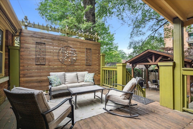 wooden deck with an outdoor living space and a gazebo