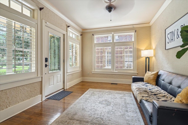 interior space featuring wood-type flooring, ceiling fan, and crown molding