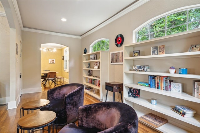 sitting room featuring crown molding, light hardwood / wood-style flooring, and a notable chandelier