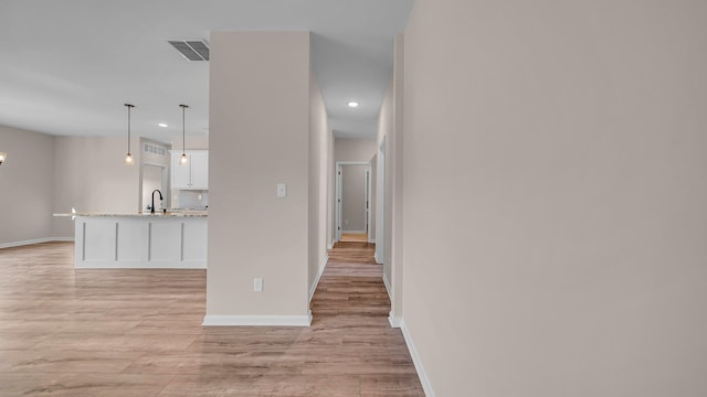 corridor featuring light hardwood / wood-style floors and sink