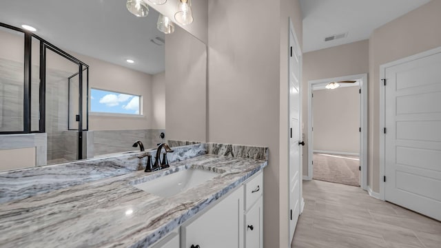 bathroom with vanity and a shower with door