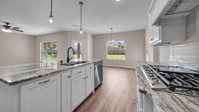 kitchen featuring a center island with sink, white cabinetry, sink, and a wealth of natural light