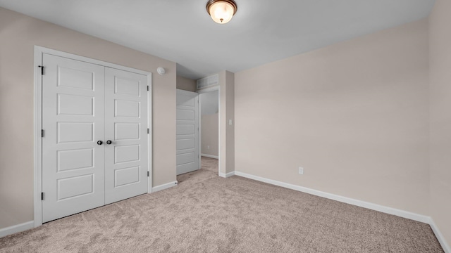 unfurnished bedroom featuring light colored carpet and a closet