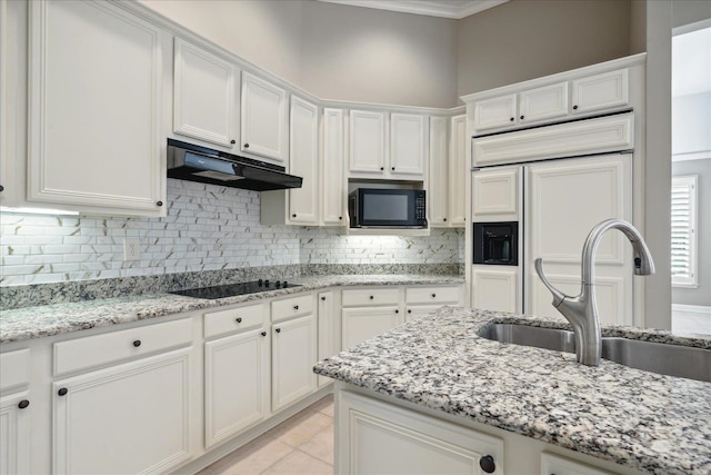 kitchen featuring black appliances, light stone countertops, sink, and white cabinets