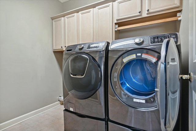 laundry area with cabinets, light tile patterned flooring, and washer and dryer