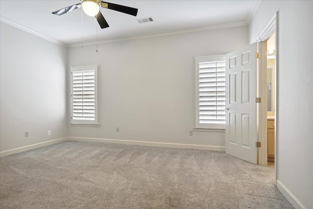 carpeted empty room featuring ceiling fan, crown molding, and a healthy amount of sunlight